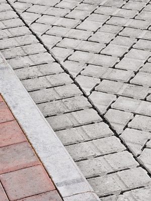 Brick paving types with pink sidewalk curb and drive made from plain interlocking concrete bricks